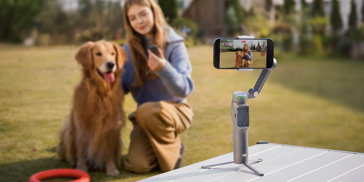 DJI Osmo Mobile 8P on its built-in tripod filming a woman and her dog